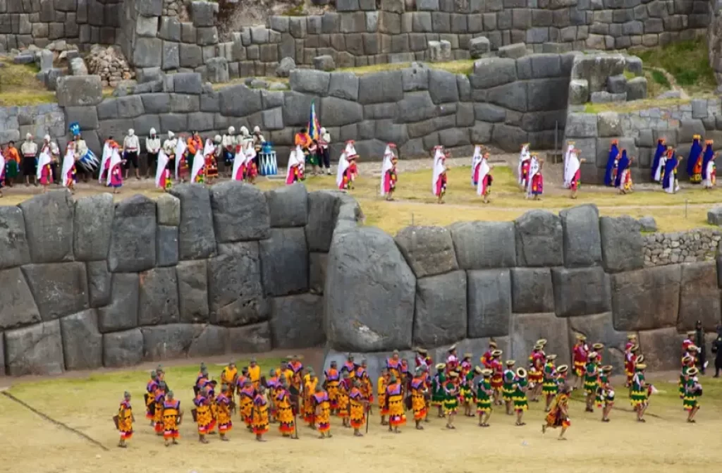 Traditional dancers perform during the Festival of the Sun, amidst ancient stone walls in Peru.