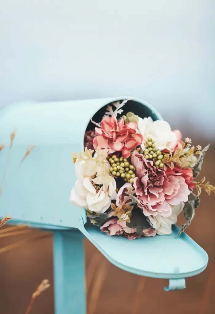 Pastel floral arrangement in a blue vintage mailbox.